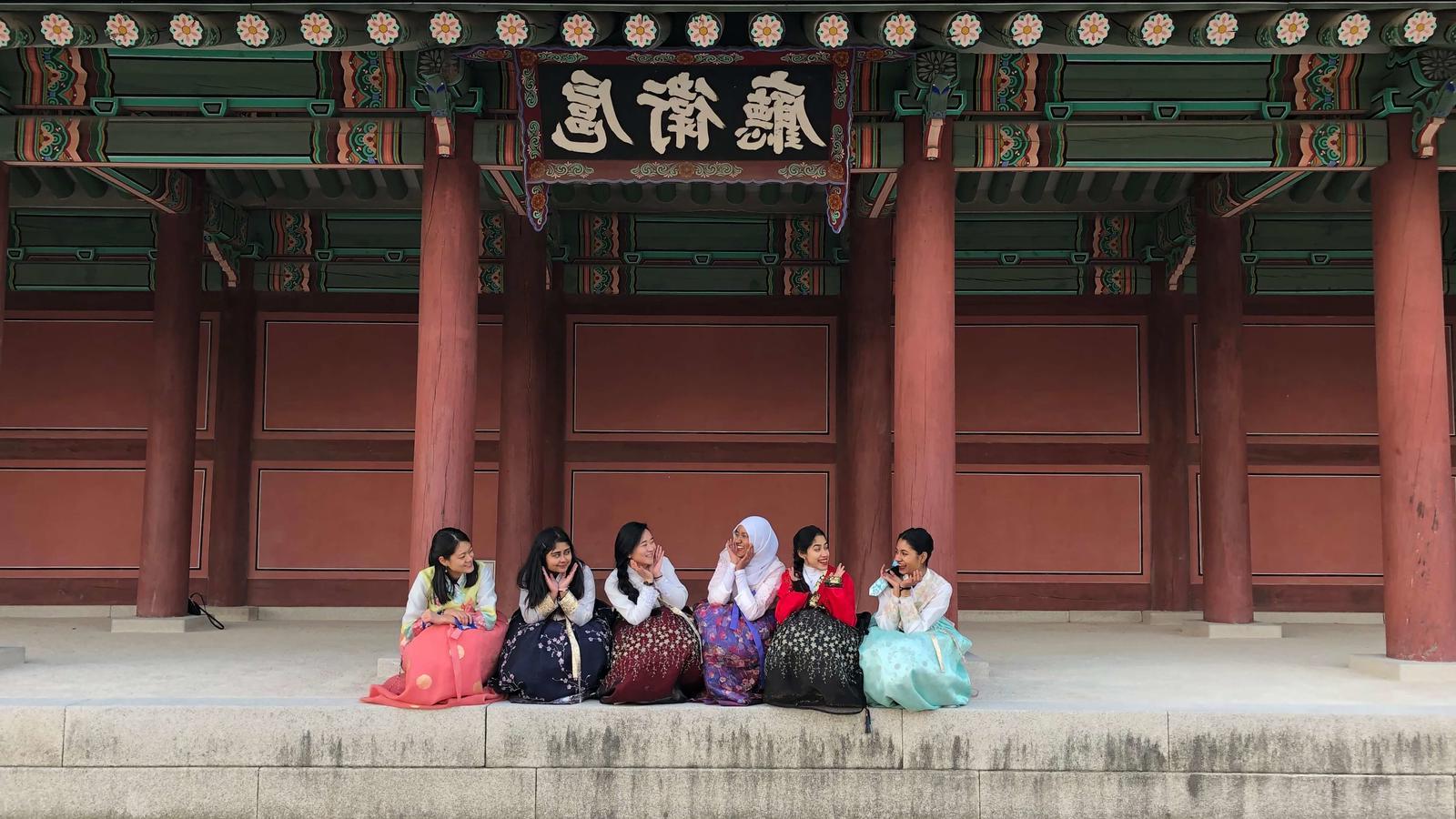 在中国，几名妇女坐在一座建筑物前
